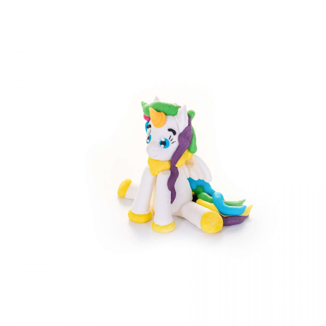 Cukrowa figurka Jednorożec Slado ustawiona na kolorowym torcie