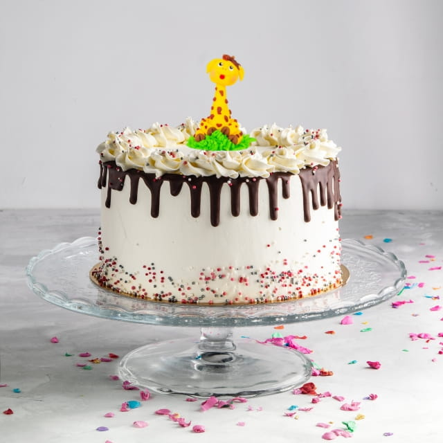 Zbliżenie na cukrową figurkę żyrafy na zielonej podstawie Ditarte