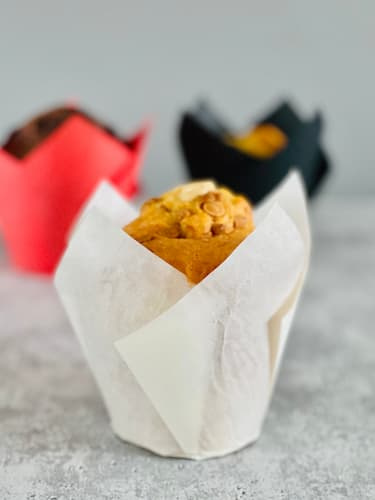 Papilotki tulipan białe wypełnione ciastem do muffinek, gotowe do włożenia do piekarnika