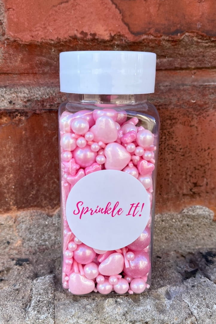Opakowanie posypki cukrowej Hello Pink 100g Sprinkle It! z bliska, widoczna struktura różowych drobinek